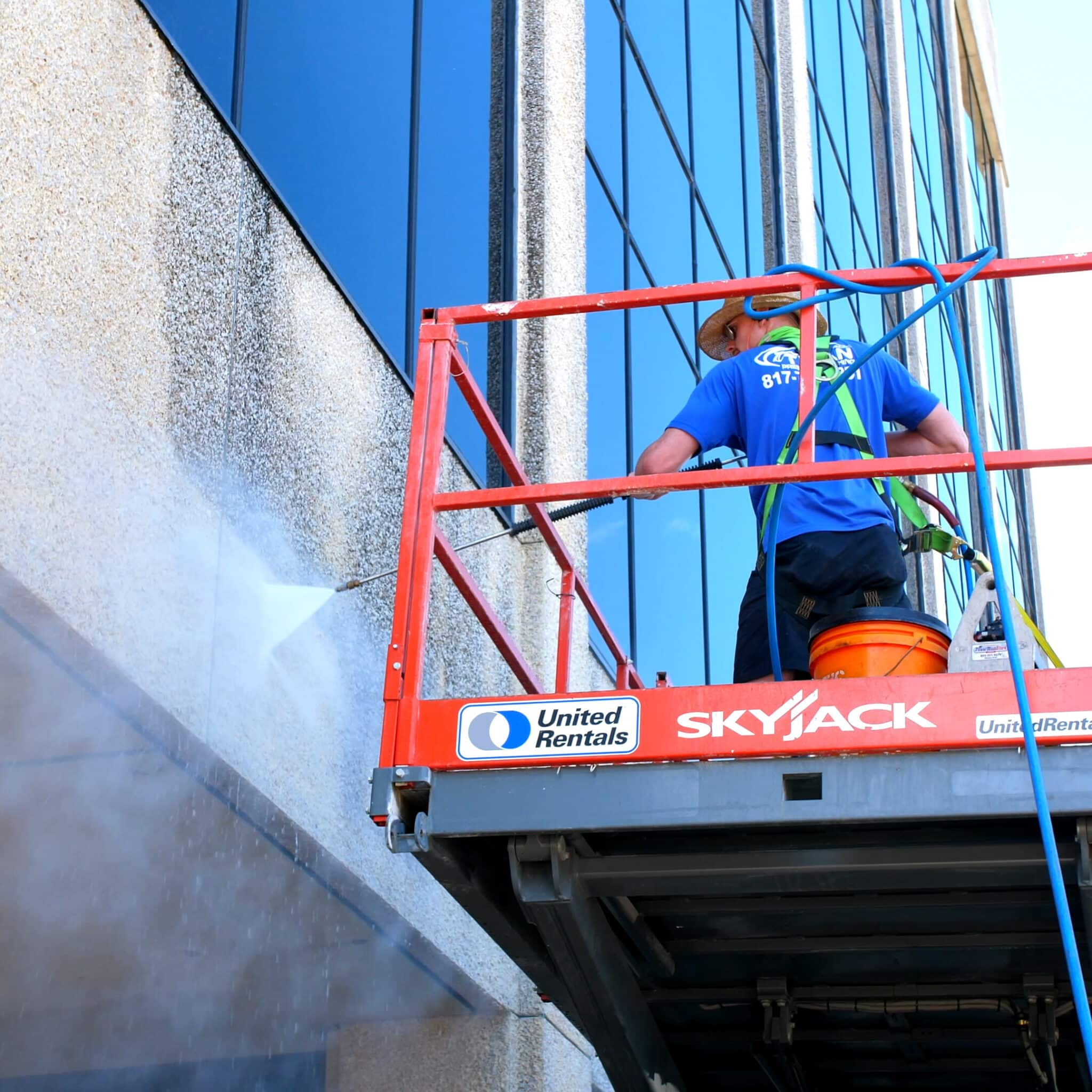 Commercial Property Services performed by Titan Pressure Washing employee on scissor lift