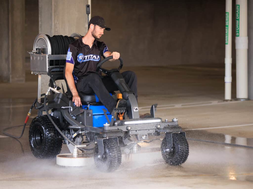 Man operating ride-on surface cleaner