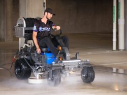 Man operating ride-on surface cleaner